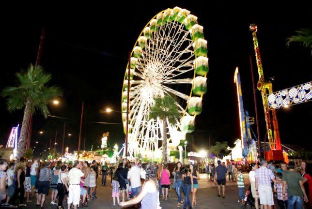 The Almería Fair at night, with a lit ferris wheel and crowds