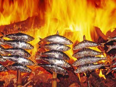 Sardinas al espeto grilling over an open fire, a local speciality