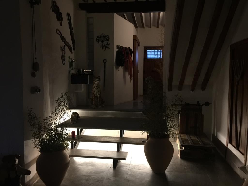 A dimly lit interior hallway at night, with ceramic leopard figures and decorative masks on the walls
