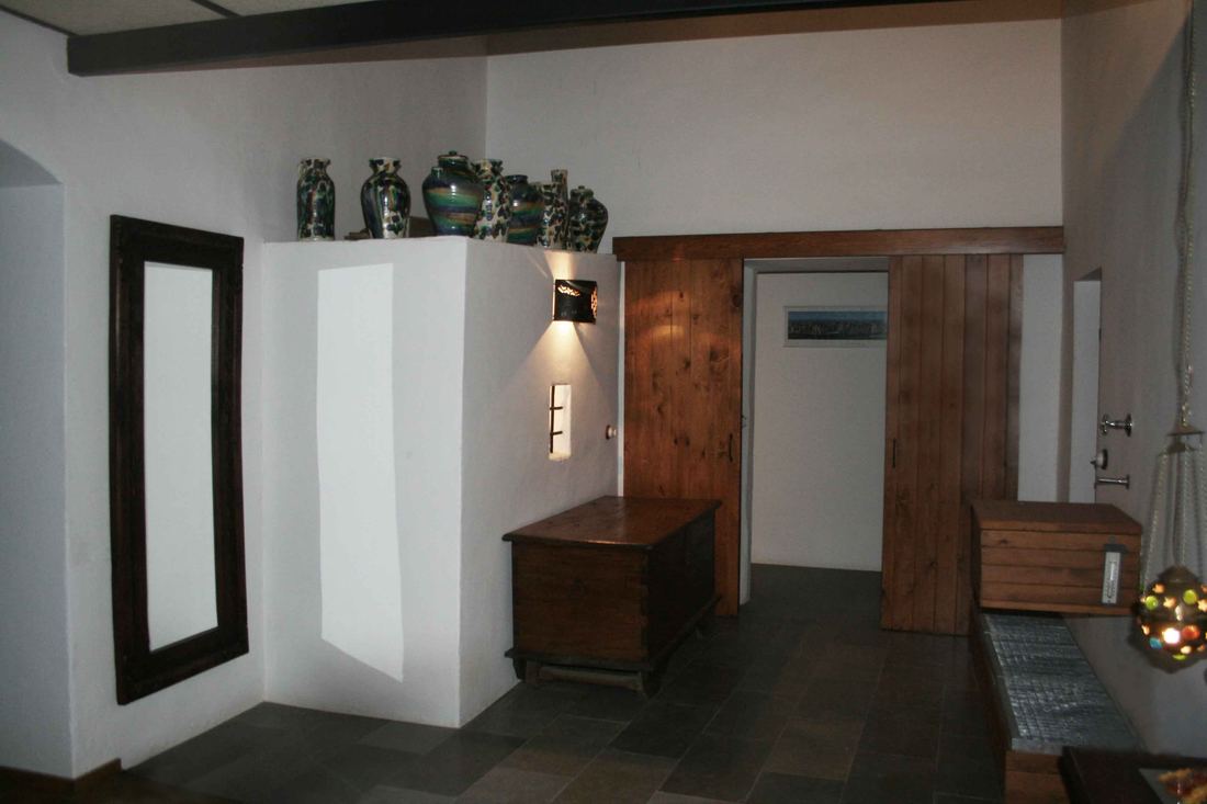 A walk-in shower room with white plastered dividing walls and blue mosaic tile, seen from a bedroom landing