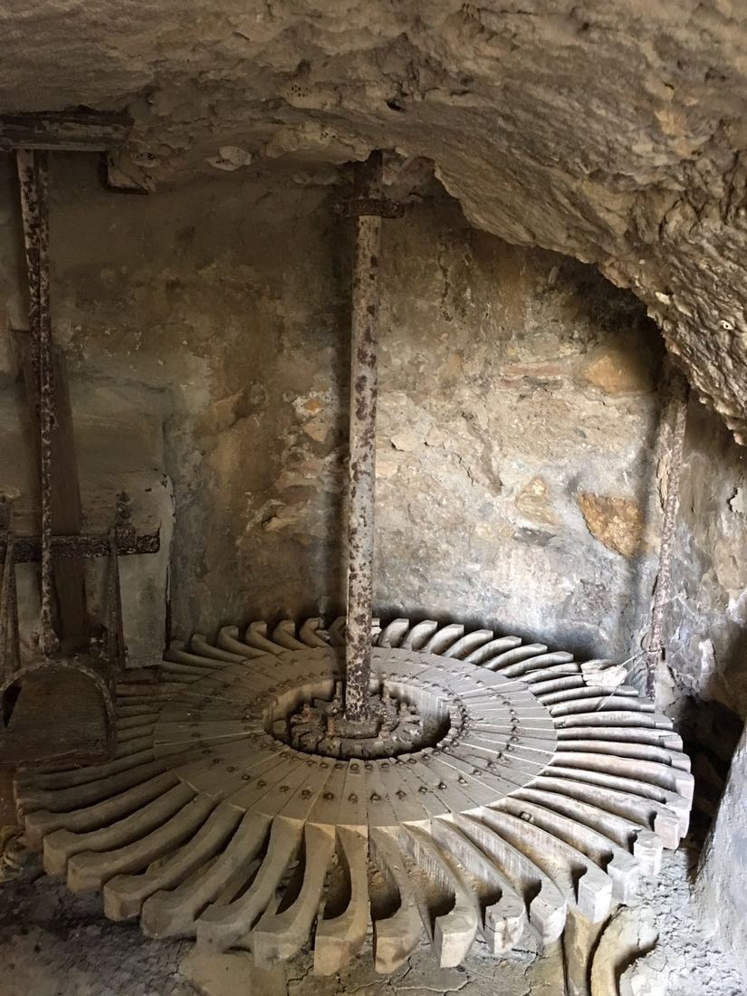 A close view of the rodezno water-wheel and its wooden blades inside the stone cárcavo