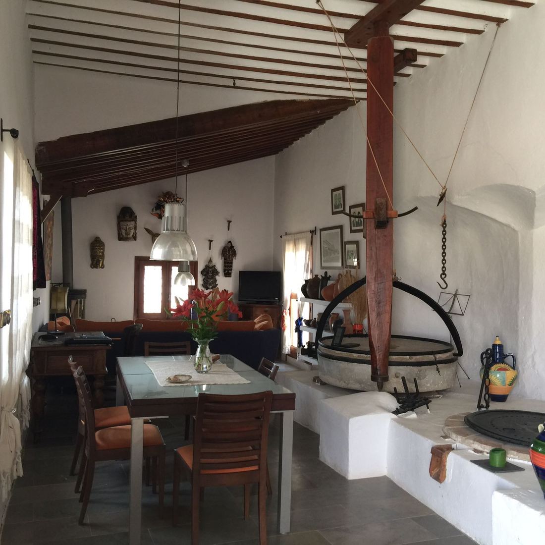 The living and dining room, with the old grinding press standing beside the dining table